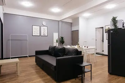 a living room with a black couch and a table at U3 Large 2 Bedroom Full kitchen near BTS Udomsuk in Bangkok