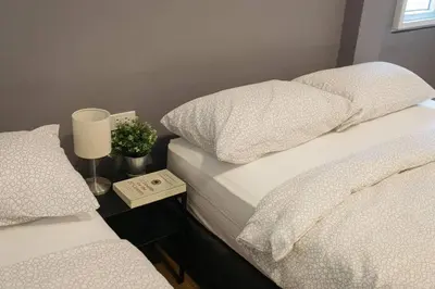 two beds with white sheets and a lamp on a night stand at U3 Large 2 Bedroom Full kitchen near BTS Udomsuk in Bangkok