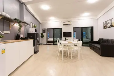 a kitchen and a living room with a table and chairs at U2 Large 2 Bedrooms 100m to BTS station in Bangkok