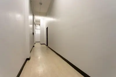 an empty hallway with white walls and a wooden floor at U2 Large 2 Bedrooms 100m to BTS station in Bangkok