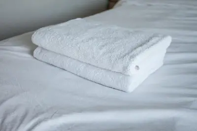 a stack of white towels sitting on top of a bed at U1 Large 2 bed rooms BTS Udomsuk in Bangkok