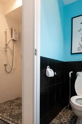 a bathroom with a toilet and a blue wall at B3 Cosy Studio /5 guests/ Near MRT/full kitchen in Bangkok