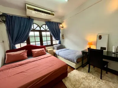 a bedroom with two beds and a desk with a computer at C U Again in Bangkok