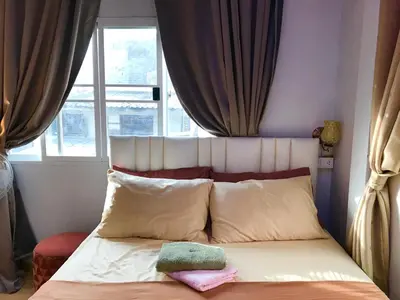 a bed with two pillows and a window in a room at C U Again in Bangkok