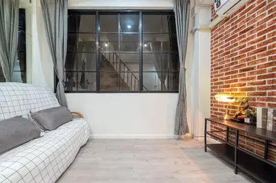 a living room with a couch and a brick wall at Mein Haus B @Bangpo in Bang Su