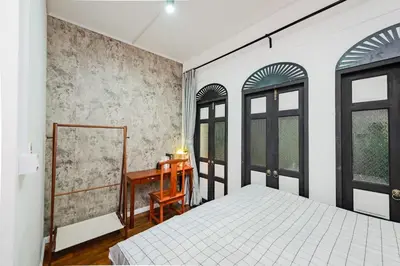 a bedroom with a bed and a desk and windows at Mein Haus B @Bangpo in Bang Su