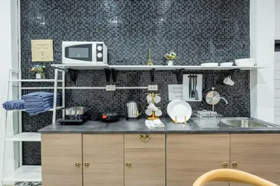 a kitchen with a counter with a sink and a microwave at Mein Haus B @Bangpo in Bang Su
