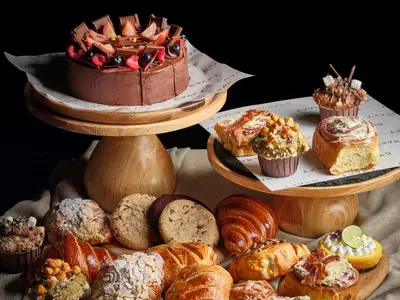a bunch of different types of pastries and cakes on plates at Kimpton Maa-Lai Bangkok by IHG in Bangkok