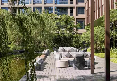 a patio with couches and chairs in front of a building at Kimpton Maa-Lai Bangkok by IHG in Bangkok