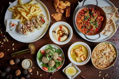 a group of plates of food on a wooden table at Kimpton Maa-Lai Bangkok by IHG in Bangkok