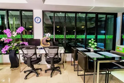 a restaurant with black chairs and a table with flowers at D Day Suite in Bangkok