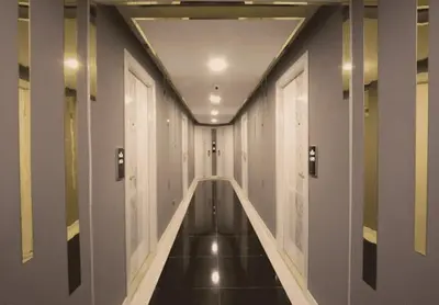 a hallway of a building with white walls and black floors at Pratunam Atrium Hotel in Bangkok