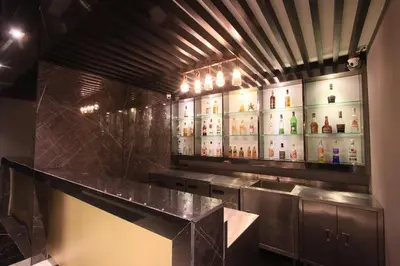 a kitchen with a counter with bottles of alcohol at Pratunam Atrium Hotel in Bangkok