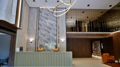 two people standing at a counter in a lobby at Grand Asoke Suites Boutique Residence in Bangkok