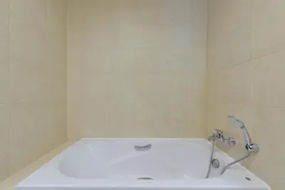 a bath tub in a bathroom with a shower at Grand Asoke Suites Boutique Residence in Bangkok