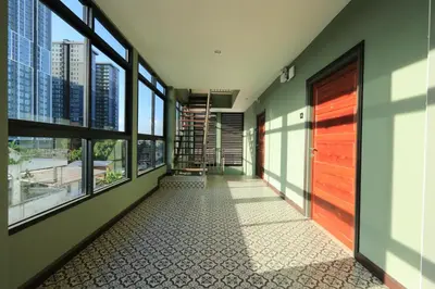 a hallway with windows and a door with a view at Baanrao Bangson in Bangkok