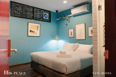 a bedroom with a bed with a blue wall at Tang House in Bangkok