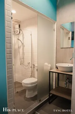 a bathroom with a toilet and a sink at Tang House in Bangkok