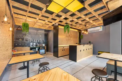 a restaurant with wooden tables and stools at LOBSUEK Hostel in Bangkok