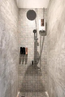a shower in a bathroom with a tile wall at LOBSUEK Hostel in Bangkok