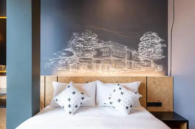 a bedroom with a bed with a picture on the wall at LOBSUEK Hostel in Bangkok