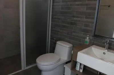 a bathroom with a toilet and a sink and a shower at Airee Premier Residence in Bangkok