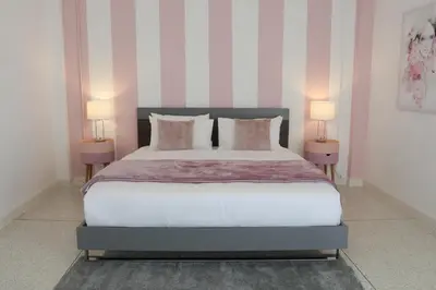 a bedroom with a large bed with two lamps at Airee Premier Residence in Bangkok
