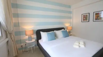 a bedroom with a bed with blue and white pillows at Airee Premier Residence in Bangkok