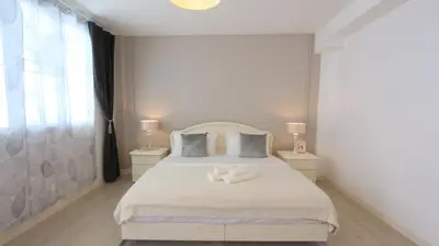 a bedroom with a white bed with two night stands at Airee Premier Residence in Bangkok
