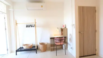 a room with a desk and a table with a chair at Airee Premier Residence in Bangkok