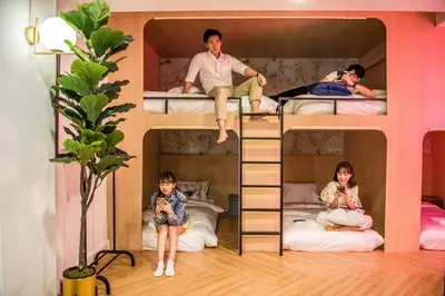 a group of people sitting in bunk beds at Theme Boutique Hotel Bangkok in Bangkok