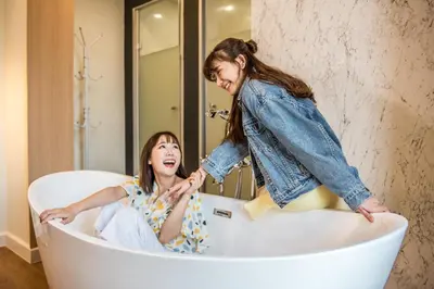 two girls are playing in a bath tub at Theme Boutique Hotel Bangkok in Bangkok