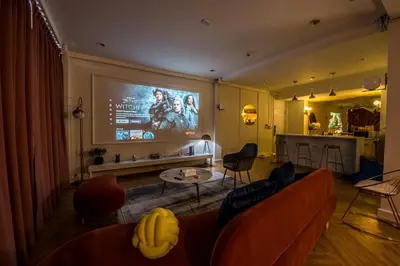 a living room with a couch and a large screen at Theme Boutique Hotel Bangkok in Bangkok