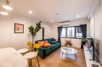 a living room with a green couch and a table at Theme Boutique Hotel Bangkok in Bangkok