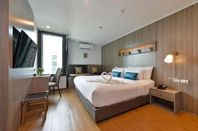 a hotel room with a large bed and a desk at StayAt Bedever Bangkok Hotel in Bangkok
