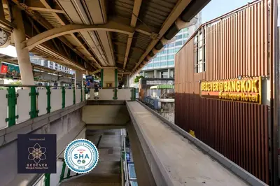 a walkway in a building with a sign on it at StayAt Bedever Bangkok Hotel in Bangkok