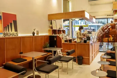 a woman standing at a counter in a restaurant at StayAt Bedever Bangkok Hotel in Bangkok