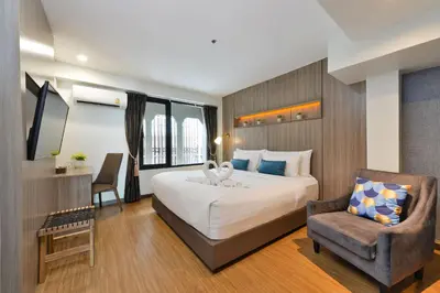 a hotel room with a bed and a chair at StayAt Bedever Bangkok Hotel in Bangkok