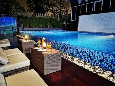a swimming pool with a table and glasses of wine at Sky dome resotel - โรงแรมสกายโดม รีโซเทล in Bangkok