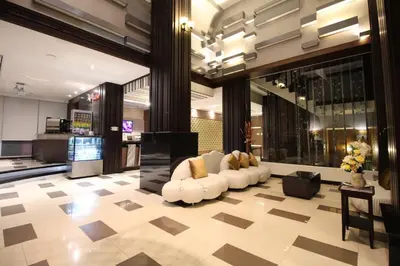 a lobby with a white couch in a building at Sky dome resotel - โรงแรมสกายโดม รีโซเทล in Bangkok