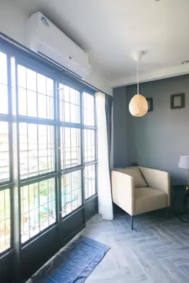 a living room with a couch and large windows at 87 Oldtown at River Pier in Bangkok