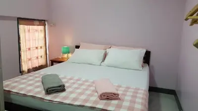 a bedroom with a bed with two towels on it at Baan U-Sabai บ้านอยู่สบาย in Bangkok