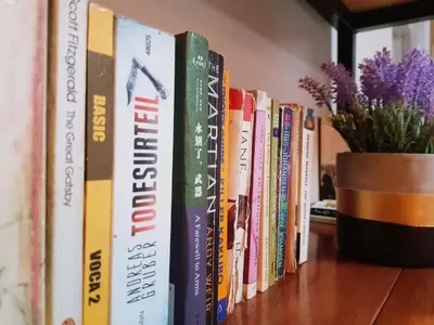 a row of books on a shelf with a potted plant at Baan U-Sabai บ้านอยู่สบาย in Bangkok