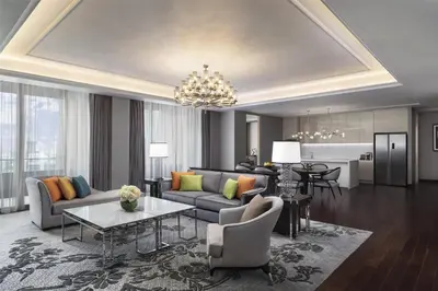 a living room with a couch and a table at Sindhorn Kempinski Hotel Bangkok in Bangkok
