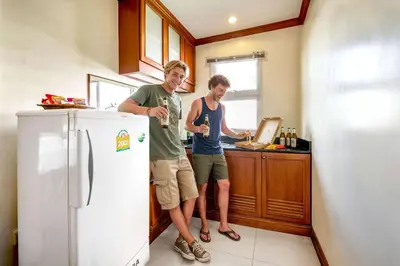two men standing in a kitchen with a refrigerator at Studio Suite by Royal Ivory Nana in Bangkok