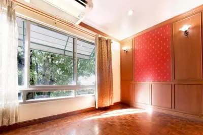 an empty room with a large window with red walls at Studio Suite by Royal Ivory Nana in Bangkok