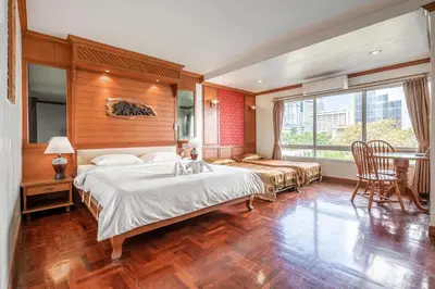 a bedroom with a large bed and a table and chairs at Studio Suite by Royal Ivory Nana in Bangkok