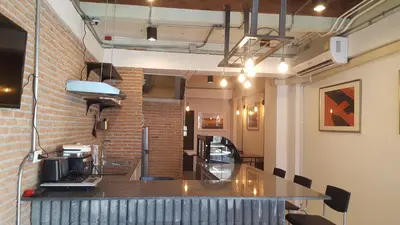 a restaurant with a counter and a brick wall at Haus Sathorn 11 Residence in Bangkok