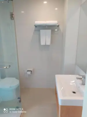 a white bathroom with a sink and a toilet at S3 Residence Park in Bangkok