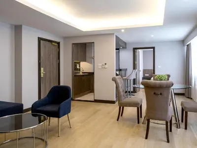 a living room with chairs and a table at Rembrandt Residences Bangkok in Bangkok